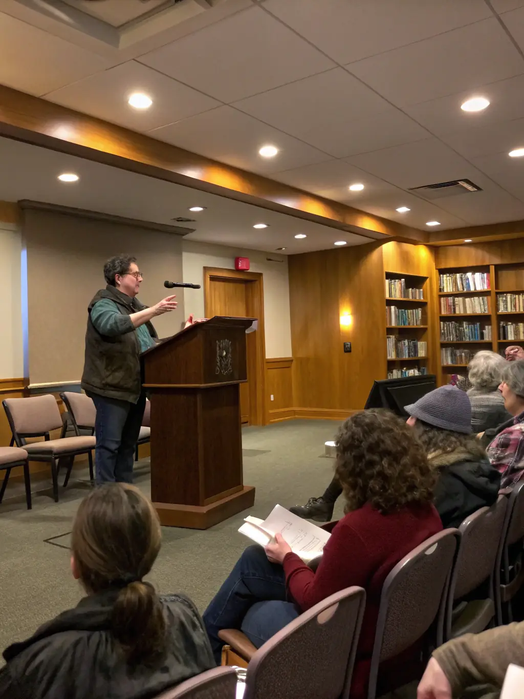 A photograph of a local author giving a talk at L'HEUR DE LIRE, with attendees listening attentively and engaging in Q&A.